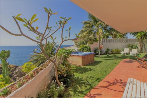 a backyard with a hot tub and the ocean at Villa in protected space in front of the sea in Los Realejos