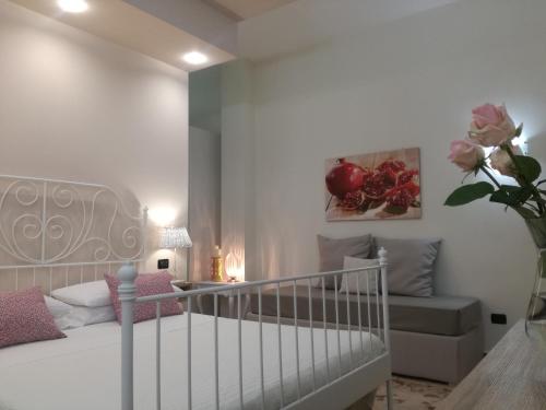a white bedroom with a bed and a couch at Casa del Corso in Taviano