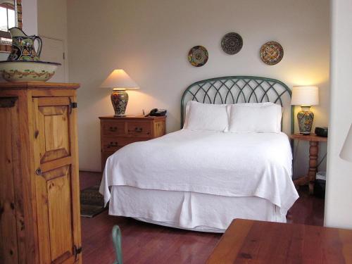 a bedroom with a white bed and a wooden table at The Penrose Bed & Breakfast in Sedona