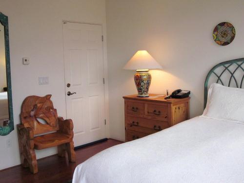 a bedroom with a bed and a chair and a lamp at The Penrose Bed & Breakfast in Sedona