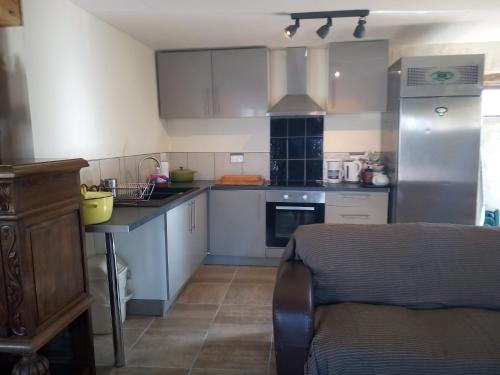 une cuisine avec des armoires blanches et un comptoir dans l'établissement Le Petit Savriere B&B, à Tronget