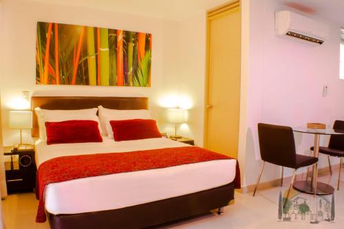 ブカラマンガにあるAmoblados Casa de Pinos Bucaramangaのベッドルーム1室(赤い枕とテーブル付きのベッド1台付)