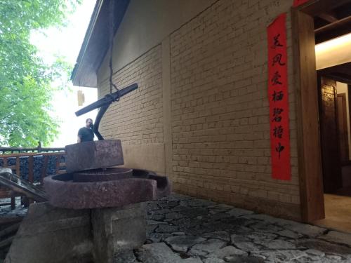 a statue of a man sitting on a fountain in front of a building at Dayong Antique Feature Resort in Zhangjiajie