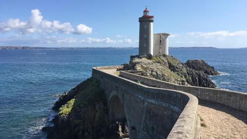 a lighthouse on a cliff next to the ocean at Bel appartement dans maison au bourg in Loc-Maria-Plouzané