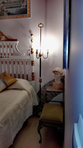 a bedroom with a bed and a table and a lamp at Império Romano Guest House in Beja