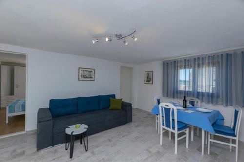 ein Wohnzimmer mit einem blauen Sofa und einem Tisch in der Unterkunft Apartment Island Dream in Krapanj