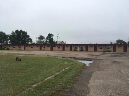 an empty building with a field in front of it at Hagman Motel in Hugoton