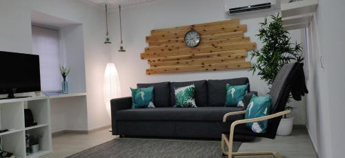 a living room with a couch and a clock on the wall at Casa do Relógio in Horta