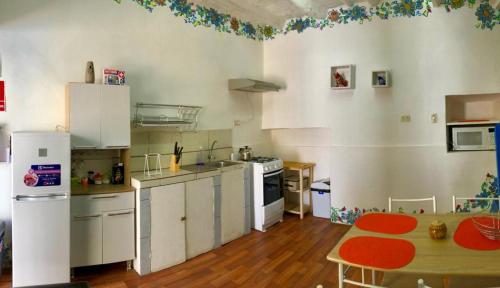 a kitchen with white cabinets and a table in it at Apartamento Cusco Queswa in Cusco