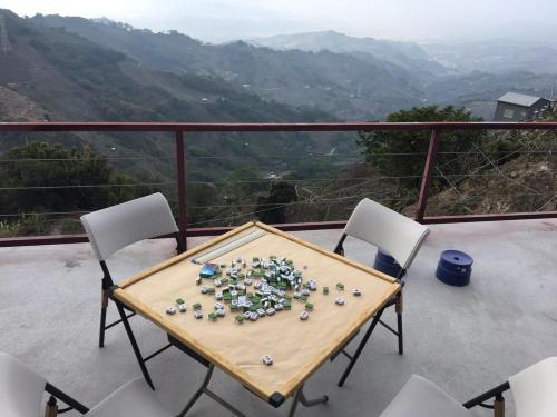 a table and chairs on a balcony with a view at 歐森View包棟Villa x 雲海夜景 x 獨立空間 in Dongshi