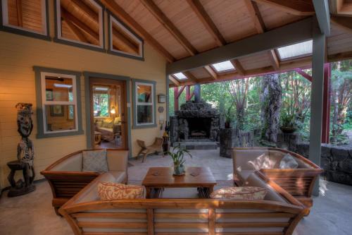 an outdoor living room with couches and a table at Volcano Mist Cottage in Volcano