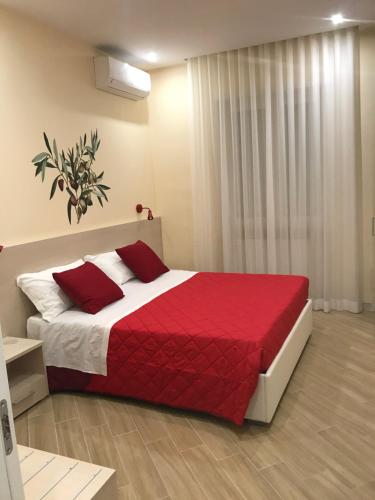 a bedroom with a large bed with a red blanket at b&b Rita, nel cuore del Salento in Cavallino di Lecce