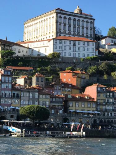 a group of buildings on a hill next to the water at Porto Private Yacht- Accommodation Douro River in Porto
