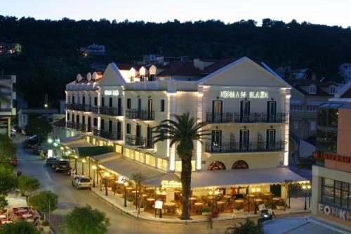 a building with a palm tree in front of a street at Ionian Plaza Hotel in Argostoli