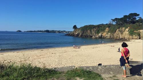 a woman standing on a beach near the water at Bel appartement dans maison au bourg in Loc-Maria-Plouzané