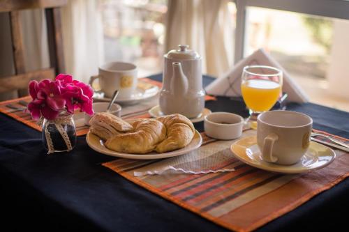a table topped with plates of croissants and orange juice at Punta Encanto Posada Boutique in Miramar
