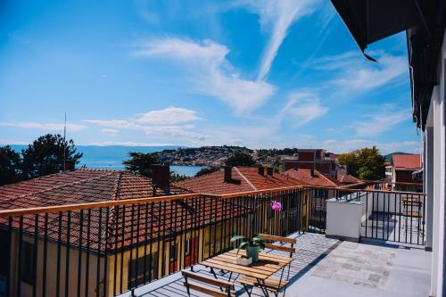 Un balcón con una mesa y sillas en un tejado. en SU Hotel, en Ohrid