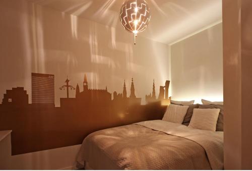 a bedroom with a bed with a city mural on the wall at The best of Copenhagen right at your doorstep no 1 in Copenhagen