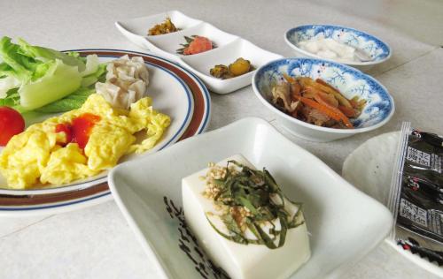 a table with plates of food and bowls of food at Traveler's Inn Asanebo in Teshikaga