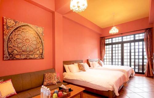 a bedroom with two beds and a couch at Lancasa Taitung in Taitung City