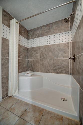 a white tub in a bathroom with a shower at Seahaven Beach Hotel Panama City Beach in Panama City Beach