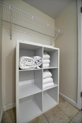 a walk in closet with white shelves and towels at Seahaven Beach Hotel Panama City Beach in Panama City Beach