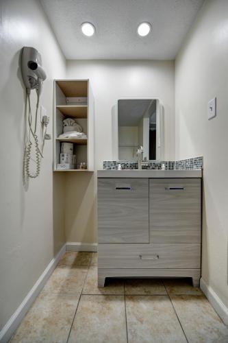 a bathroom with a sink and a mirror at Seahaven Beach Hotel Panama City Beach in Panama City Beach