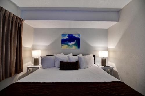 a bedroom with a large bed with two lamps at Seahaven Beach Hotel Panama City Beach in Panama City Beach
