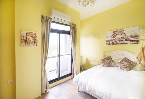 um quarto com uma cama branca e uma janela em Lancasa Taitung em Taitung City