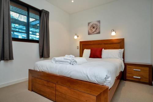 a bedroom with a large bed with towels on it at QV Stylish Waterfront Apartment - 317 in Auckland