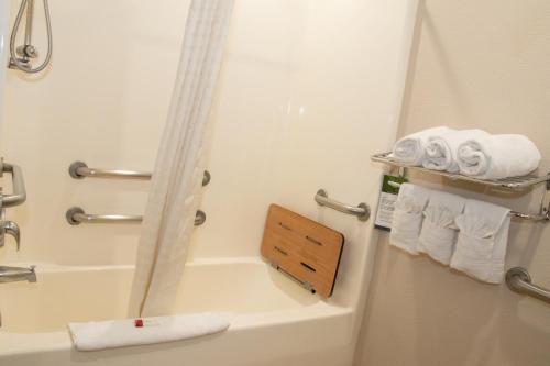a bathroom with a tub and a shower with towels at Microtel Inn & Suites Lodi in Lodi