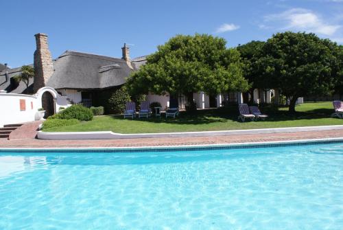 a large swimming pool in front of a house at Whale Rock Luxury Lodge in Hermanus