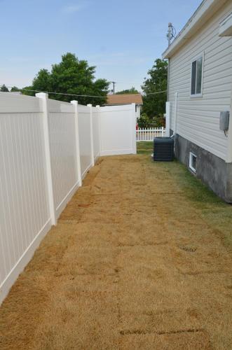 a white fence next to a house at Baby Blue Sky - Price 2bd - Newly remodeled - nearby trails in Price