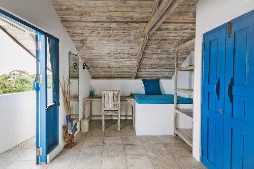 Zimmer mit einer blauen Tür, einem Schreibtisch und einem Etagenbett in der Unterkunft Bali Bio Villas in Uluwatu