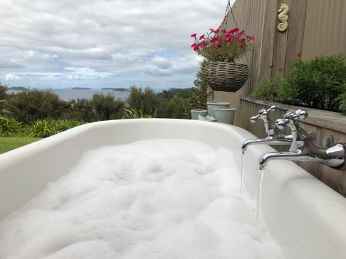 a bath tub filled with snow in a yard at Kākā Ridge Retreat Luxury Cottage in Tawharanui