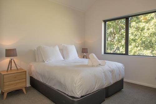 a bedroom with a large bed with a window at Cherry Apartment in Queenstown