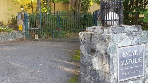 a sign on top of a stone pillar with a gate at Villa Indigo Sunny 1BR Apartment in Private Gated Estate in Charlotte Amalie
