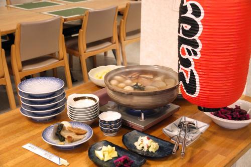 a table topped with plates and a bowl of food at Hotel Yuzawa Yuzawa Denkiya in Yuzawa