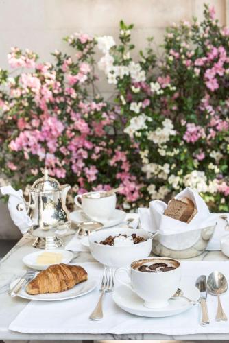 a table with cups and saucers of coffee and cookies at Palacio Duhau - Park Hyatt Buenos Aires in Buenos Aires