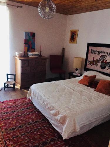 - une chambre avec un lit, une commode et un lustre dans l'établissement Maison de village, à Ortiporio