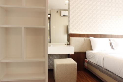 a bedroom with a bed and a sink and a mirror at Gorgeous 2BR Apartment at Gateway Pasteur near Exit Toll By Travelio in Bandung