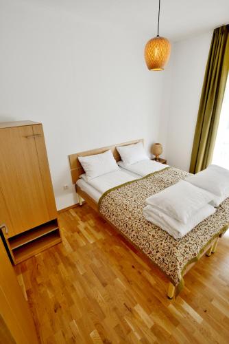a bedroom with two beds and a wooden floor at Draugų namai in Druskininkai