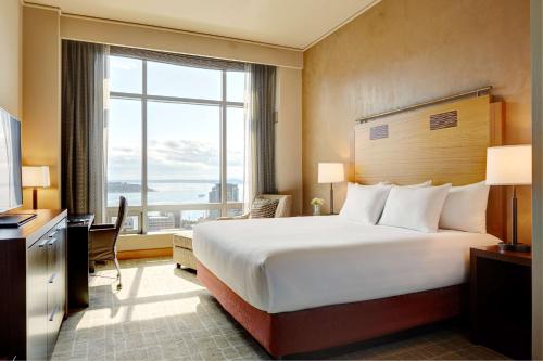 um quarto de hotel com uma cama e uma grande janela em Grand Hyatt Seattle em Seattle