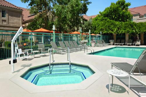 a swimming pool with lounge chairs and a swimming pool at Hyatt House Pleasanton in Pleasanton