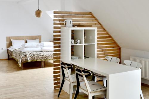 a dining room with a table and chairs and a bed at Draugų namai in Druskininkai