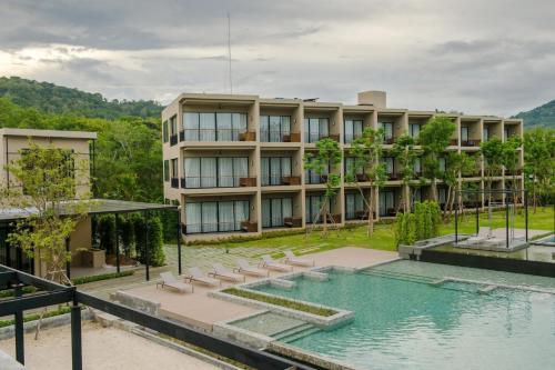 an exterior view of a building with a swimming pool at The Gallery Hotel Nai Harn in Nai Harn Beach
