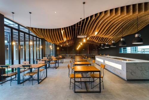 a restaurant with tables and chairs and windows at The Gallery Hotel Nai Harn in Nai Harn Beach