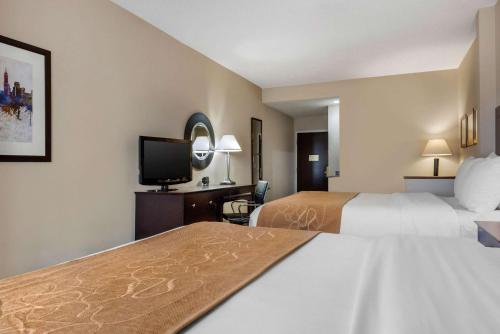 a hotel room with two beds and a flat screen tv at Comfort Suites Lafayette University Area in Lafayette