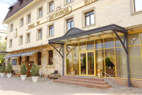a building with a sign on the front of it at Sacvoyage Hotel in Almaty