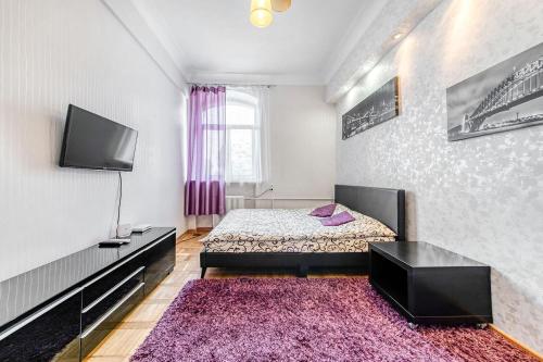 sypialnia z łóżkiem i telewizorem na ścianie w obiekcie Apartment on Karl Marx Street w Mińsku